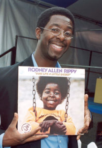 Rodney Allen Rippy holding album of his from 1973