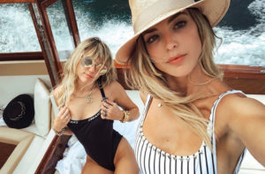 Miley Cyrus Wearing Chanel One Piece Bathing Suit, Chanel Necklace and Sunglasses With Kaitlynn Carter Wearing Hat And Stripped One Piece Bathing Suit